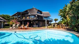 a house with a swimming pool in front of it at Sea Breeze Apartment in Wilderness
