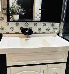 a bathroom with a white sink and a mirror at Calm Corner Addis in Addis Ababa +35 photos
