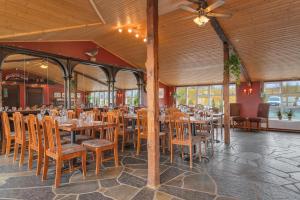 una sala da pranzo con tavoli e sedie in legno di Hestakráin Guesthouse a Selfoss