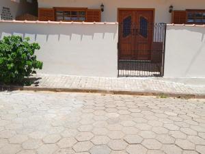 a white building with a door and a brick driveway at Loft Bourbon - Ideal para casais, família e trabalho in Itanhandu