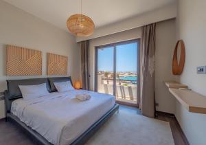 a bedroom with a large bed and a large window at Luxury Stays in Ancient Sands, El Gouna in Hurghada +84 photos