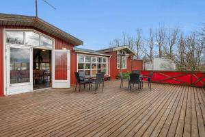 una terrazza in legno con sedie e un tavolo sopra di Hestakráin Guesthouse a Selfoss