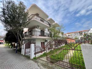 una casa bianca con un cancello davanti di PELEKAN rooms and apartments athina 12 a Pefkohori