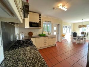 een keuken met witte kasten en een rode tegelvloer bij Spacious Villa in Vila Nova de Gaia in Vila Nova de Gaia