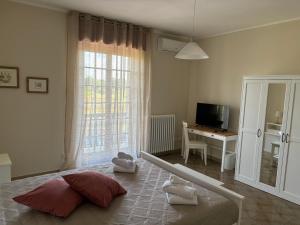 a bedroom with a bed and a desk and a window at Terrarossa in Crispiano