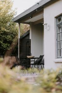 un patio con sedie e un tavolo in una casa di Platteland Cottage a Clarens