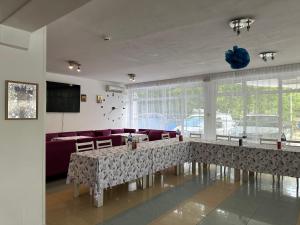 a living room with a table and a couch at Парк-хотел РИВА in Golden Sands