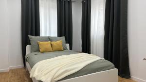 a bed with two pillows on it in a room at Appartement cosy parking privé in Tarbes