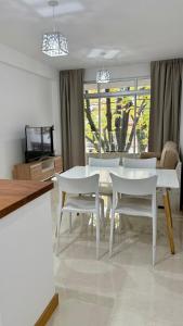 a dining room with a white table and white chairs at Alma in La Plata