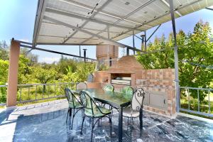 a patio with a table and chairs and an outdoor oven at Ferme de vacances avec une grande villa à Marrakech in Marrakech