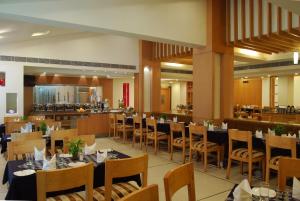 a restaurant with tables and chairs and a bar at Lords Plaza Ankleshwar in Ankleshwar