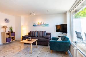 a living room with a couch and a tv at Ankerlicht in Norddeich
