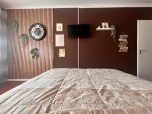 a bedroom with a bed and a clock on a wall at N3 Apartment in Amadora
