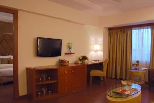 a living room with a room with a desk and a television at Lords Plaza Ankleshwar in Ankleshwar
