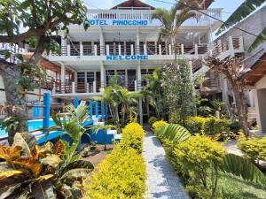 un edificio con un jardín delante en Hotel y Restaurante Pinocchio, en San Pedro La Laguna