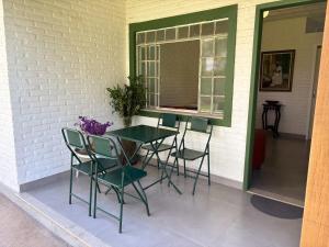 a table and chairs on a patio with a window at Casa de campo in Itaúna +13 photos