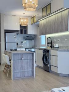a large kitchen with a washer and dryer at Comfy Hotel Apartament in Madinaty