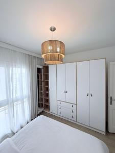 a bedroom with a bed and a chandelier at Comfy Hotel Apartament in Madinaty