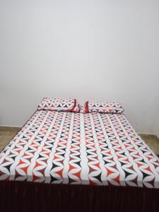 a bed with a red and white comforter at EBORA Afro Cultural in Ilhéus