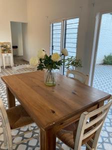 un tavolo di legno con un vaso di fiori sopra di San Alfonso a Córdoba