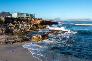 a house on the edge of a rocky beach at Thalassa in Bettyʼs Bay +8 photos