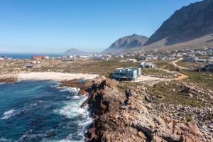 a view of a beach with houses and the ocean at Thalassa in Bettyʼs Bay