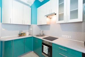 モスクワにあるLux-Apartmentsの青色のキッチン(白いキャビネット、シンク付)
