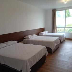 a hotel room with three beds and a window at Casa in Ahuashiyacu