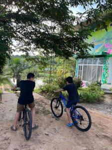 two men on bikes in front of a house at Casa in Ahuashiyacu