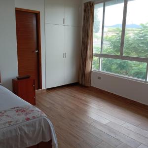 a bedroom with a bed and a large window at Casa in Ahuashiyacu