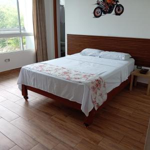 a bed in a bedroom with a motorcycle on the wall at Casa in Ahuashiyacu