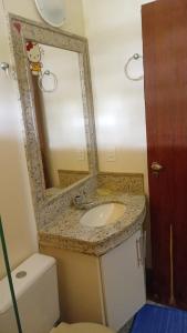 a bathroom with a sink and a mirror and a toilet at Castelo da Lagoa in Lagoa Santa