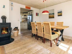 a dining room with a table and a fireplace at Unique Coastal Retreat - By Traum Ferienwohnungen in Hadsund