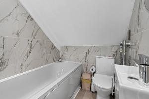 a bathroom with a tub and a toilet and a sink at Archway Haven - 2 min from Station - Free Parking - Courtyard in Swindon +25 photos