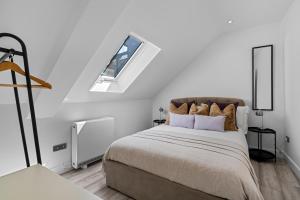 a white bedroom with a bed with a window at Archway Haven - 2 min from Station - Free Parking - Courtyard in Swindon