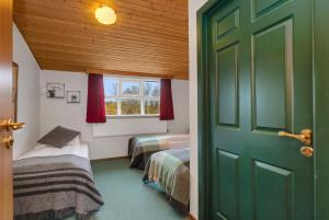 una camera con due letti e una porta verde di Hestakráin Guesthouse a Selfoss Altre 10 foto