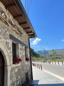 a stone building with flowers on the side of a road at Gimis House Hotel in Berat
