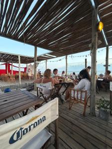 un grupo de personas sentadas en una mesa en una cubierta en Departamento frente al mar Sauce Grande REFUGIOS DEL SAUCE, en Monte Hermoso 51 fotos más