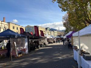 a street with tents and people walking through a market at Cosy renovated 2 bed villa in superb location in Hobart