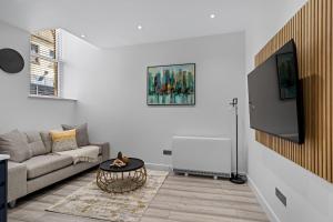 a living room with a couch and a flat screen tv at Serene Haven - 2 min from Station - Free Parking - Courtyard in Swindon