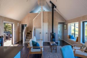 un salon avec boiseries et un escalier dans l'établissement Woodside Bay Cottage, Woodside Bay - Be My Guest Waiheke, à Waiheke Island