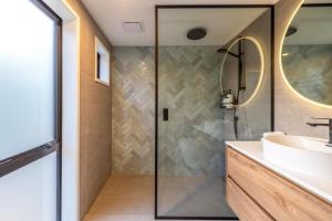 une salle de bain avec douche et lavabo dans l'établissement Woodside Bay Cottage, Woodside Bay - Be My Guest Waiheke, à Waiheke Island 31 autres photos