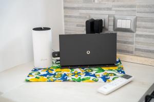 a laptop sitting on a table with a remote control at The Cave On The Sea in Meta