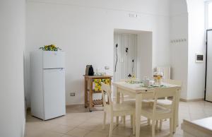 a kitchen with a white table and a white refrigerator at The Cave On The Sea in Meta