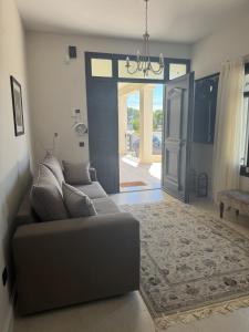 a living room with a couch and an open door at The Mulberry House Heritage by the Sea in Alexandroupoli