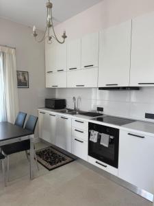 a kitchen with white cabinets and a table and a sink at The Mulberry House Heritage by the Sea in Alexandroupoli