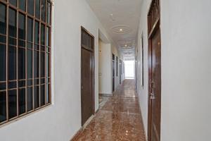 an empty corridor in a building with wooden doors at Hotel O NIKKU HOTEL in Noida