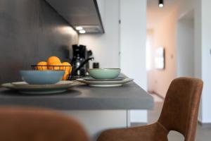 Una mesa con dos cuencos y naranjas encima. en Apartments by the sea Baska, Krk - 24433, en Baška 9 fotos más