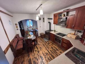 una cucina con pavimenti in legno e tavolo di Holiday house with a parking space Kamenski Hrib, Gorski kotar - 24427 a Plešce