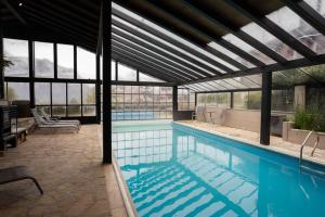 a large swimming pool with a large glassconservatory at Arelauquen Bungalows & Suites in San Carlos de Bariloche